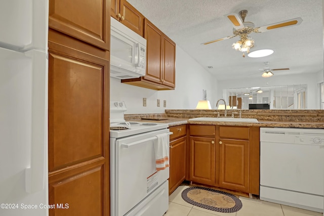 kitchen featuring ceiling fan, sink, a textured ceiling, white appliances, and light tile patterned floors