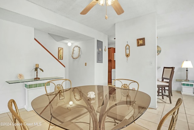 tiled dining area featuring ceiling fan, a textured ceiling, and electric panel