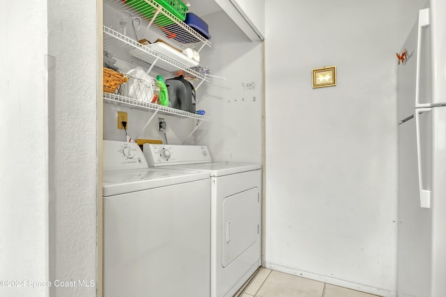 laundry area featuring light tile patterned floors and washer and clothes dryer