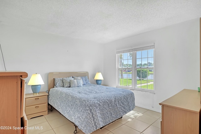 bedroom featuring light tile patterned floors and a textured ceiling