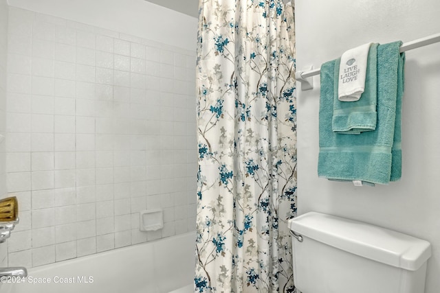 bathroom featuring shower / bath combination with curtain and toilet