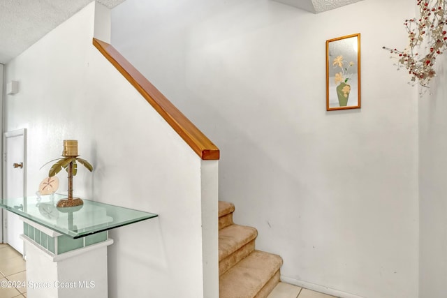 stairs featuring a textured ceiling and tile patterned floors