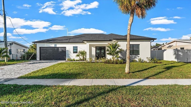 view of front of property featuring a garage, a front yard, decorative driveway, and stucco siding