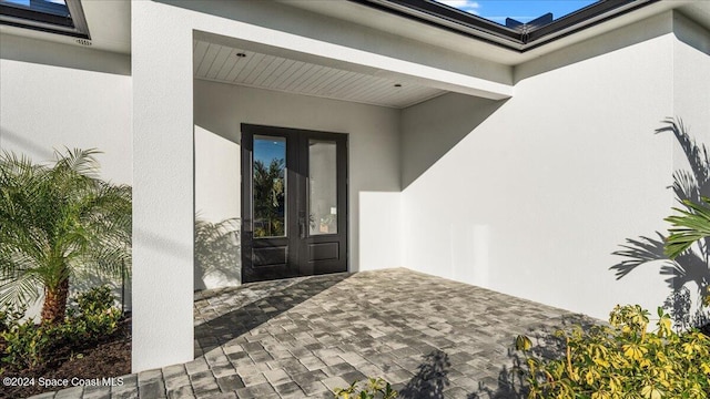 entrance to property with french doors and stucco siding