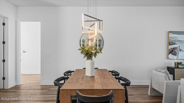 dining space with baseboards and wood finished floors