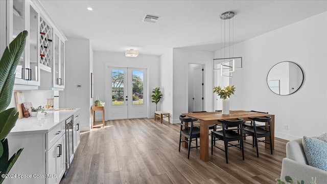 dining room with baseboards, visible vents, wood finished floors, and french doors