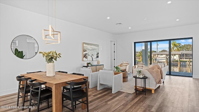 dining room featuring baseboards, wood finished floors, visible vents, and recessed lighting