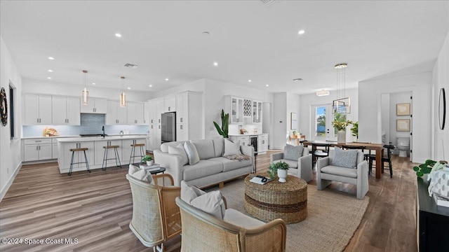 living area with recessed lighting, light wood-style flooring, and baseboards