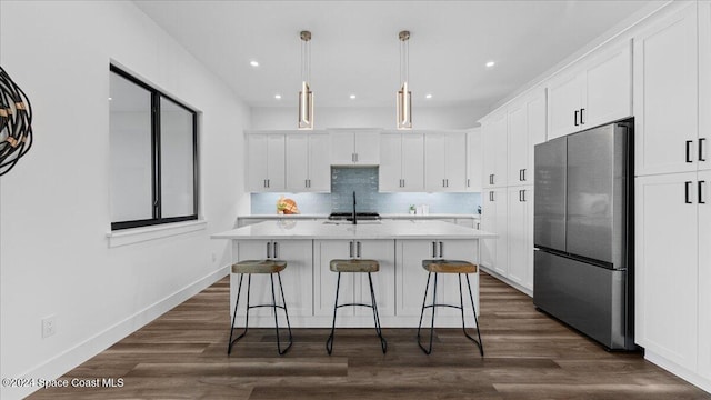 kitchen with white cabinets, dark wood-type flooring, and freestanding refrigerator