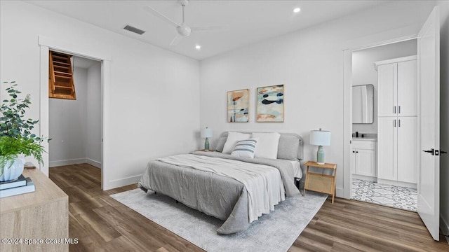 bedroom with baseboards, visible vents, connected bathroom, wood finished floors, and recessed lighting