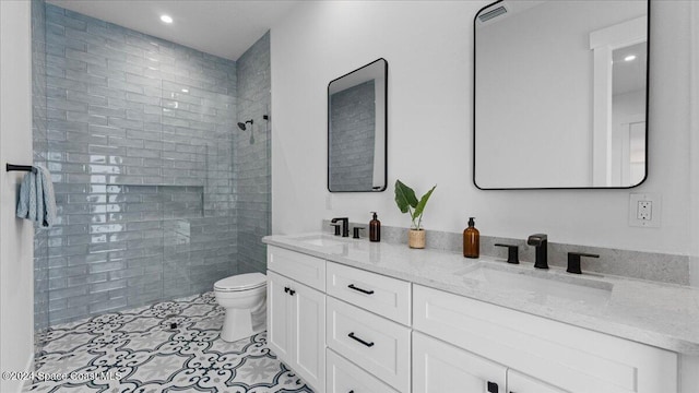 bathroom featuring double vanity, a sink, toilet, and walk in shower