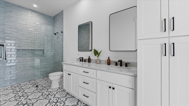 full bathroom with double vanity, toilet, a sink, a walk in shower, and tile patterned floors