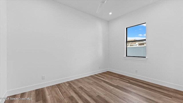 empty room with ceiling fan, recessed lighting, wood finished floors, and baseboards