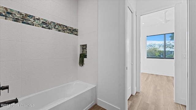 full bath featuring baseboards and wood finished floors