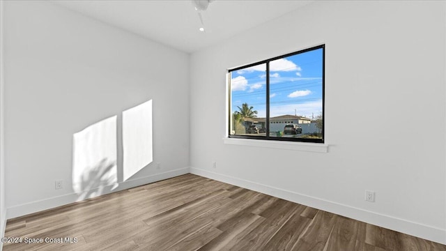 unfurnished room featuring baseboards and wood finished floors