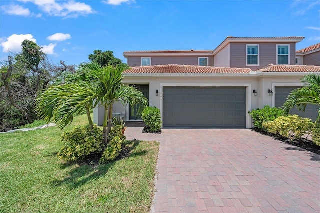 mediterranean / spanish-style home featuring a garage and a front lawn