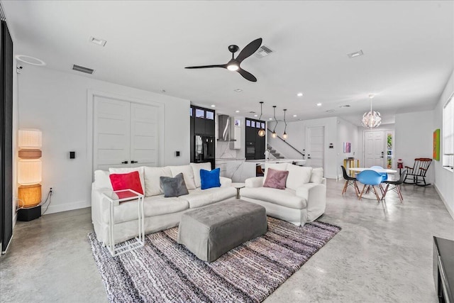 living room with ceiling fan with notable chandelier