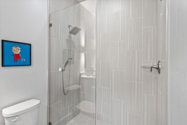 bathroom featuring tiled shower and toilet