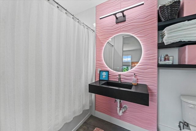 full bathroom featuring hardwood / wood-style floors, toilet, shower / bath combo with shower curtain, and sink