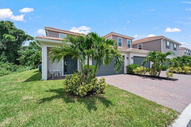 mediterranean / spanish-style home featuring a garage and a front lawn