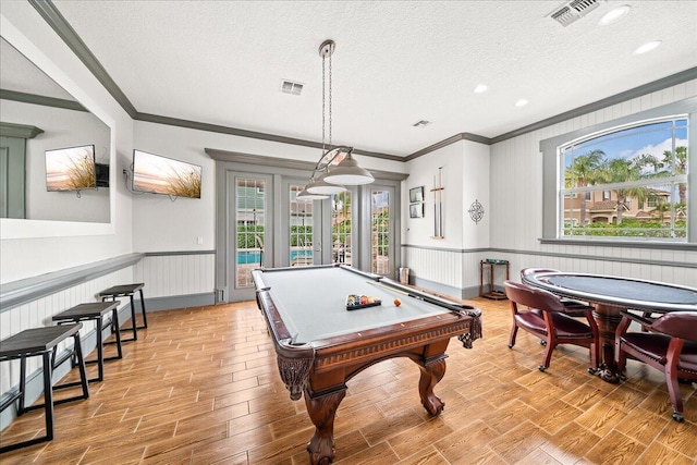 rec room featuring pool table, a textured ceiling, a wealth of natural light, and light hardwood / wood-style flooring