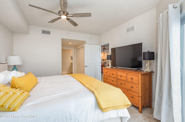 bedroom featuring ceiling fan and a textured ceiling