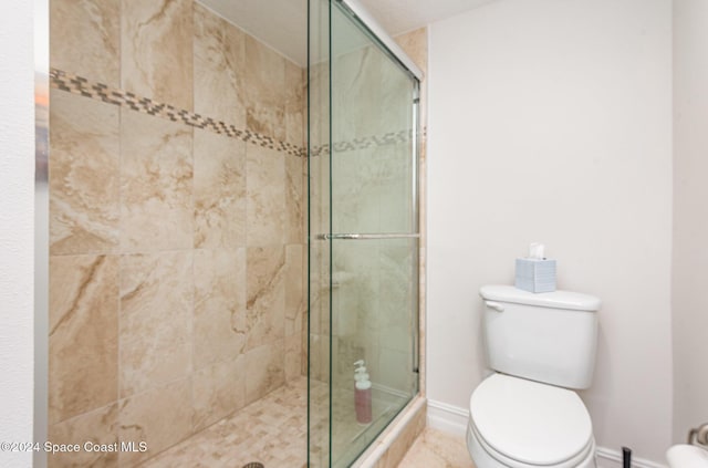 bathroom featuring toilet and an enclosed shower