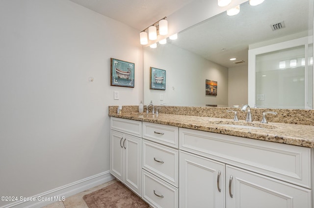 bathroom featuring tile patterned flooring, vanity, and a textured ceiling