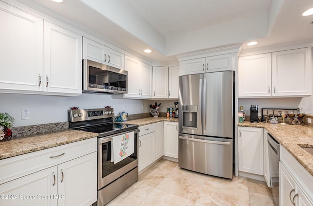 kitchen with white cabinets, light stone counters, and stainless steel appliances