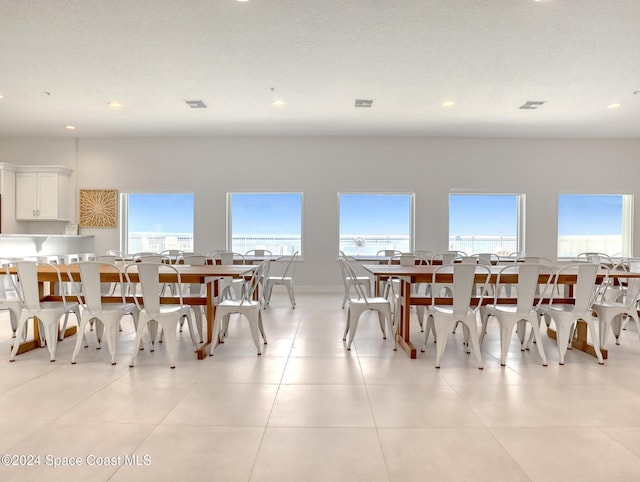 tiled dining space featuring plenty of natural light and a textured ceiling