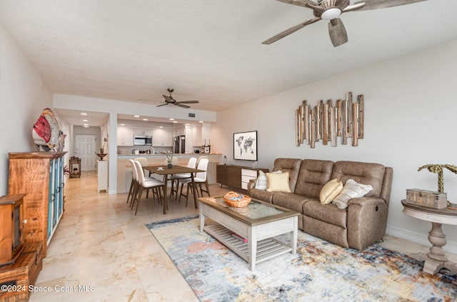 living room featuring ceiling fan and a textured ceiling