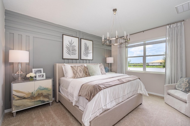 carpeted bedroom featuring a water view, wooden walls, and an inviting chandelier