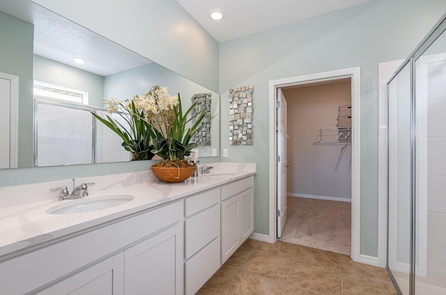 bathroom featuring a textured ceiling, vanity, tile patterned floors, and an enclosed shower