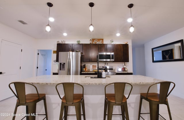 kitchen featuring a spacious island, appliances with stainless steel finishes, and decorative light fixtures