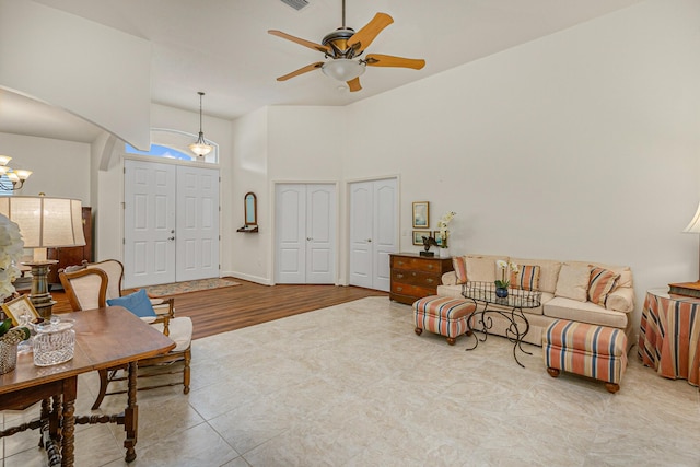 living room with ceiling fan with notable chandelier and light hardwood / wood-style flooring