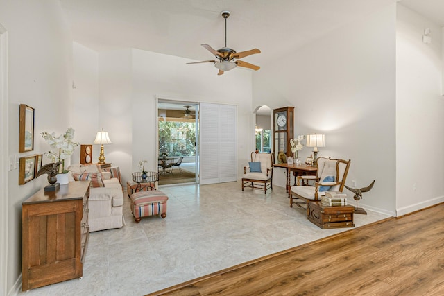 living area featuring ceiling fan, high vaulted ceiling, and light hardwood / wood-style floors