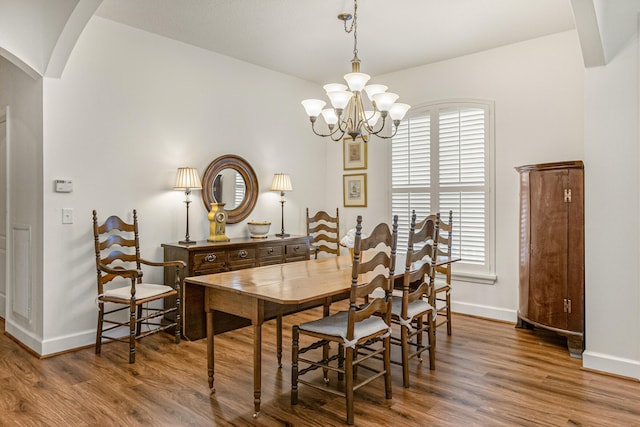 dining space with dark hardwood / wood-style flooring and a chandelier