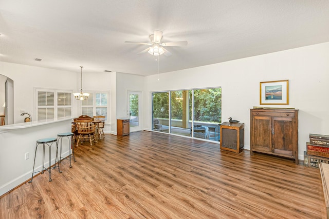 living room featuring a textured ceiling, ceiling fan with notable chandelier, and hardwood / wood-style flooring