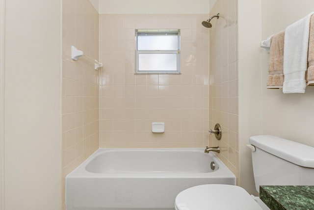 bathroom featuring tiled shower / bath and toilet