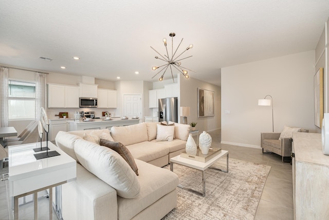 living room featuring light tile patterned floors, a textured ceiling, and an inviting chandelier