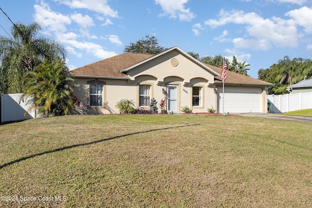 single story home with a garage and a front lawn