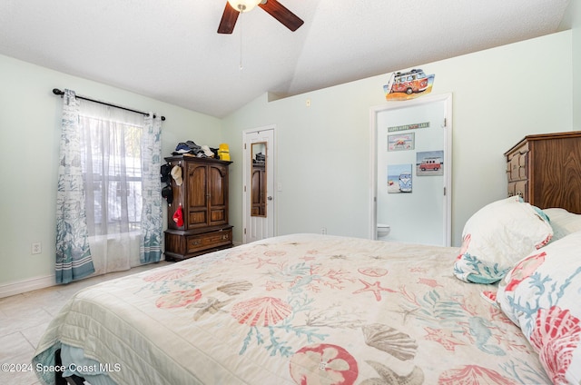 tiled bedroom with ensuite bath, ceiling fan, a textured ceiling, vaulted ceiling, and a closet