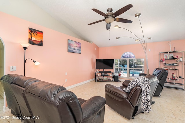 living room with ceiling fan, light tile patterned floors, and vaulted ceiling