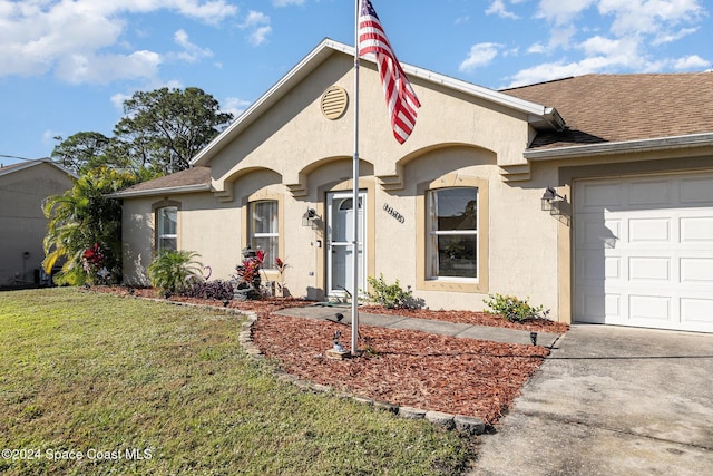 single story home with a garage and a front lawn