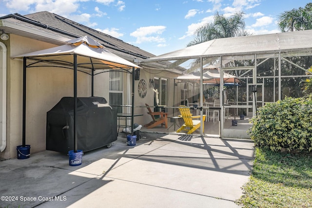 view of patio with a gazebo, area for grilling, and glass enclosure