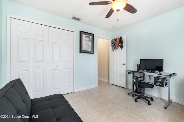 tiled home office featuring ceiling fan and a textured ceiling