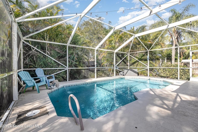 view of pool with a patio area and glass enclosure