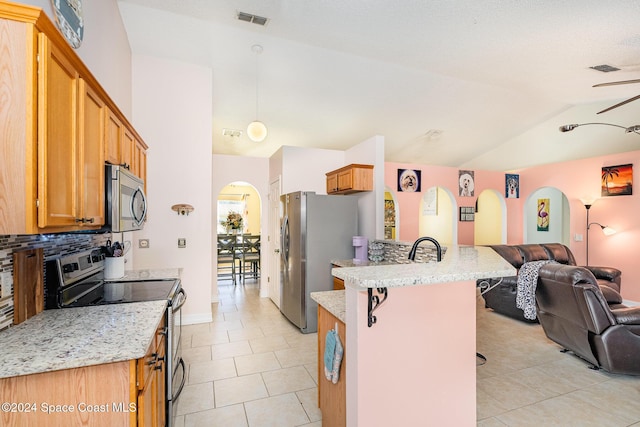 kitchen with a kitchen breakfast bar, tasteful backsplash, light stone counters, light tile patterned floors, and appliances with stainless steel finishes