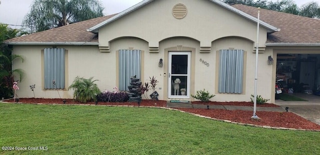 single story home featuring a front yard and a garage