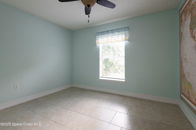 tiled empty room featuring ceiling fan and a textured ceiling